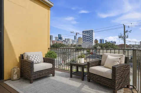 a roof deck with couches and potted plants