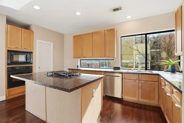 a kitchen with stainless steel appliances granite countertop a stove a sink and a refrigerator