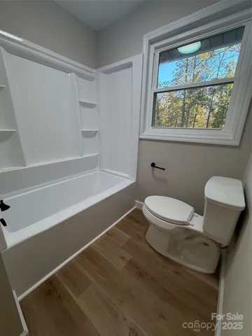 a white toilet sitting next to a window