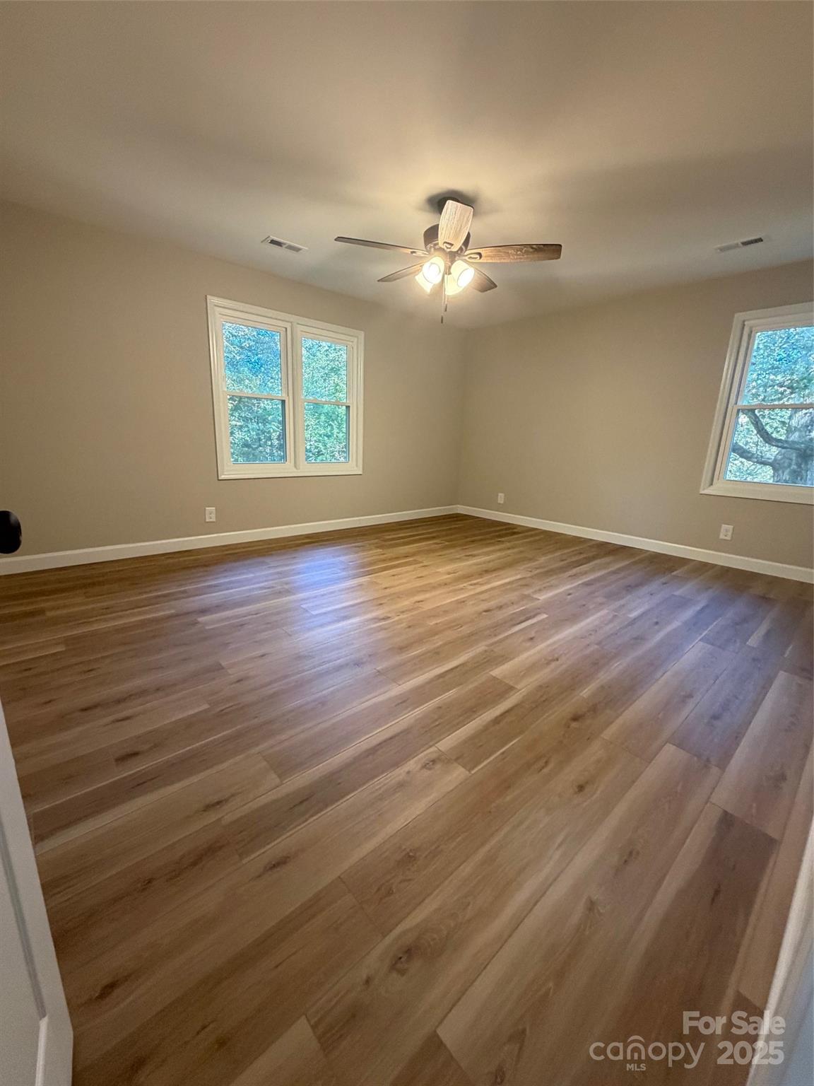 1470 Requa Road Cherryville, NC 28021 - Photo 14 of 28 an empty room with wooden floor chandelier fan and windows