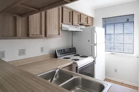 a kitchen with stainless steel appliances granite countertop a sink a stove and a refrigerator