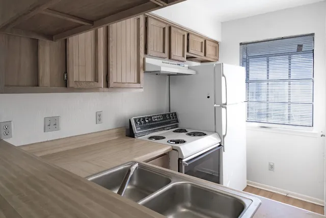 a kitchen with stainless steel appliances granite countertop a sink a stove and a refrigerator