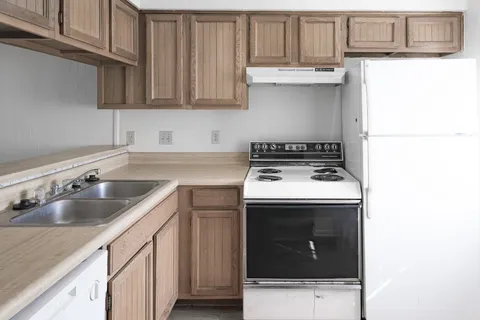 a kitchen with a sink a stove and cabinets