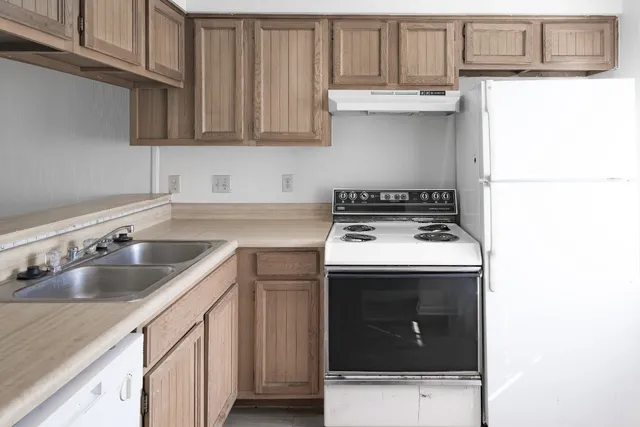 a kitchen with a sink a stove and cabinets