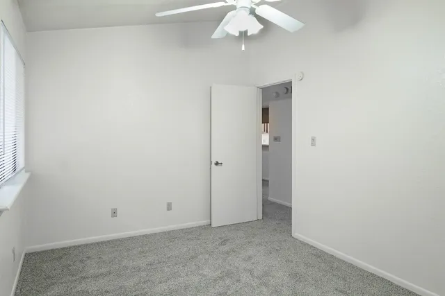 an empty room with a chandelier fan