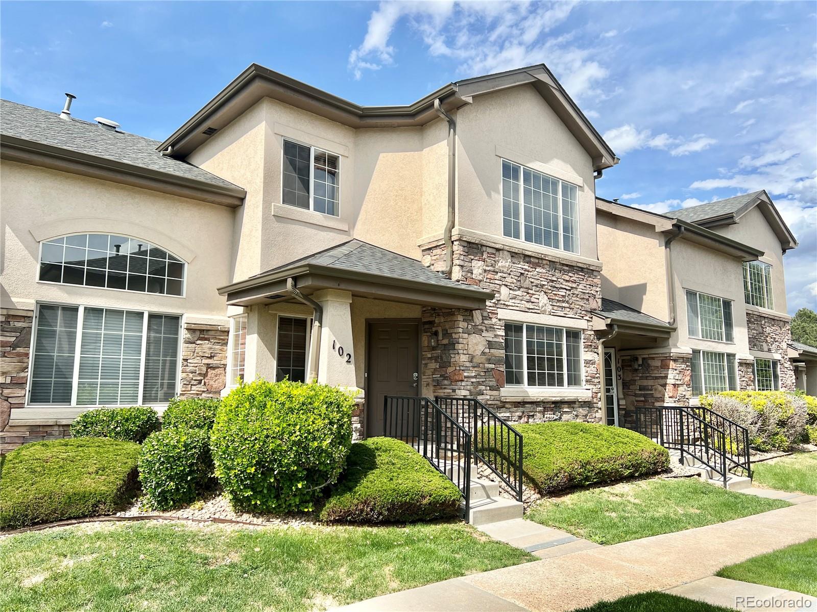 1385 South Chambers Road, Unit 102 Aurora, CO 80017 - Photo 2 of 20 a front view of a house with a yard