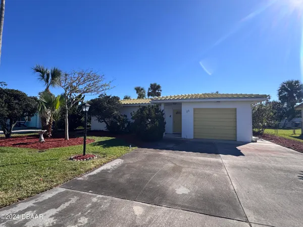 a view of a house with backyard and trees