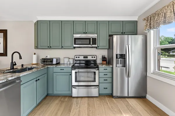 a kitchen with stainless steel appliances granite countertop a stove top oven microwave and cabinets
