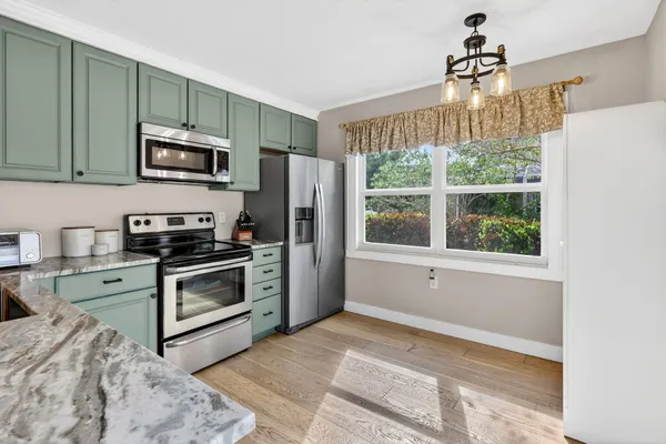 a view of a dining room with furniture wooden floor and a chandelier