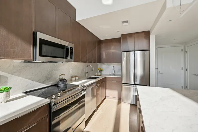 a kitchen with stainless steel appliances a stove a sink and a refrigerator