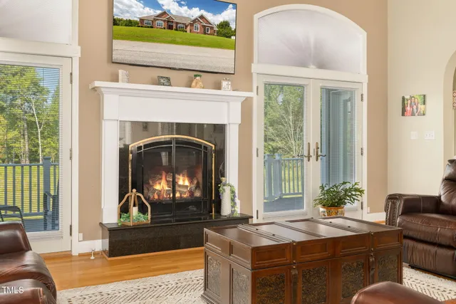 a living room with furniture fireplace and a large window
