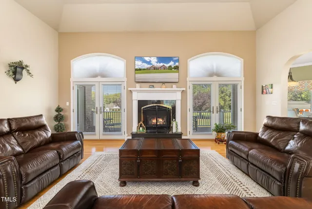 a living room with furniture fireplace and a large window