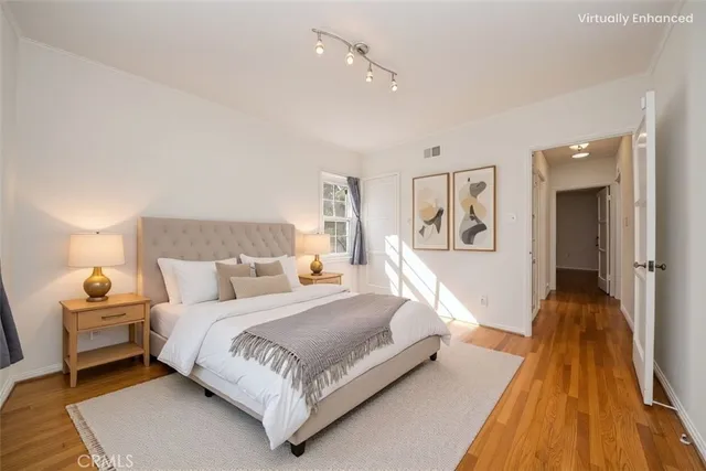 a bedroom with a bed and wooden floor