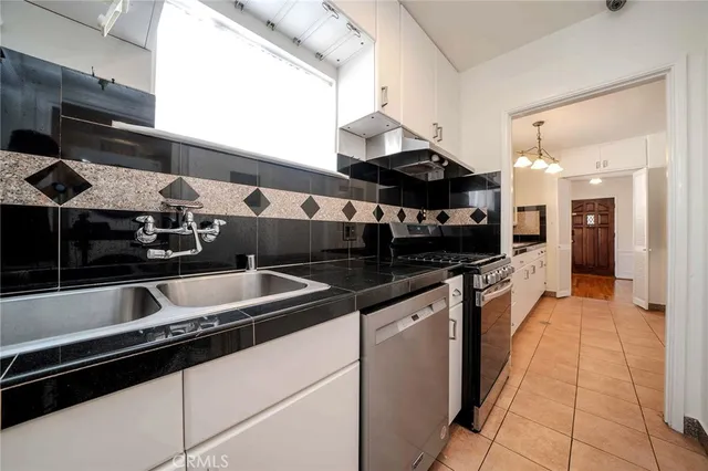 a kitchen with stainless steel appliances granite countertop a sink and a stove