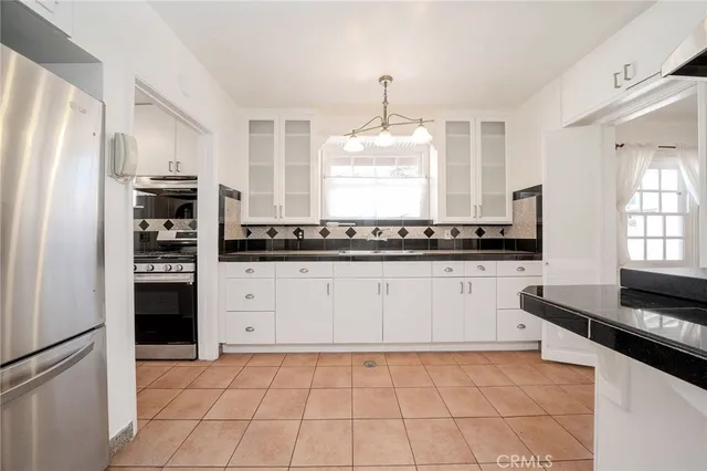 a kitchen with stainless steel appliances a refrigerator sink and stove