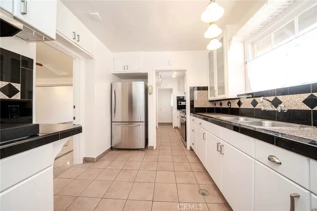 a kitchen with stainless steel appliances a refrigerator sink and cabinets