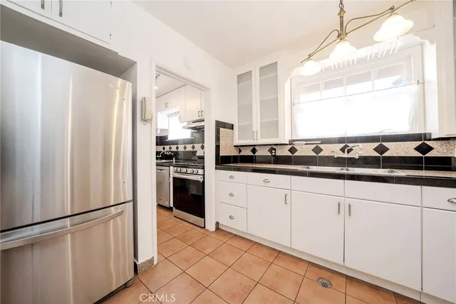 a kitchen with stainless steel appliances a refrigerator sink and cabinets