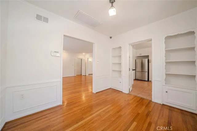 a view of empty room with wooden floor