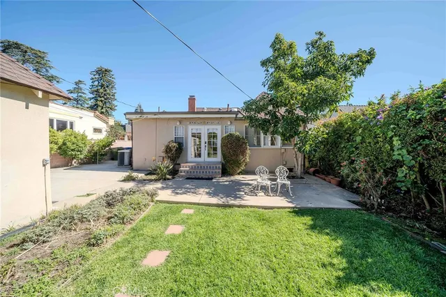 a view of a house with backyard and sitting area