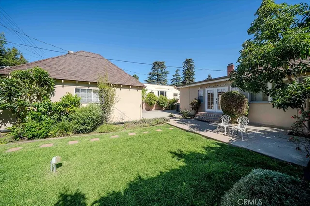 a view of a backyard with table and chairs under an umbrella