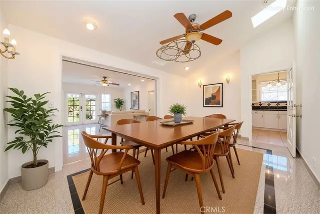 a view of a dining room and livingroom with furniture a rug a potted plant and a chandelier