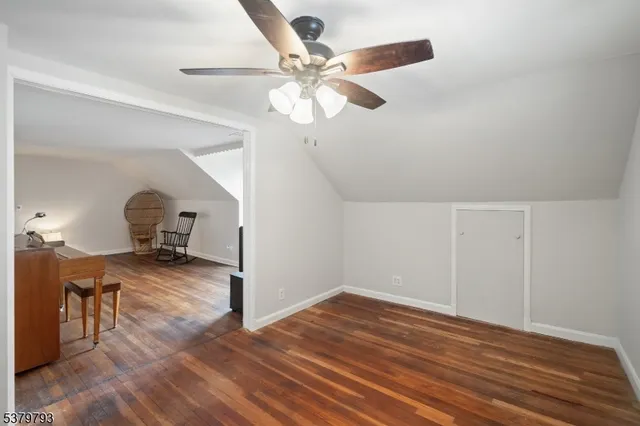 a view of a room with wooden floor and ceiling fan