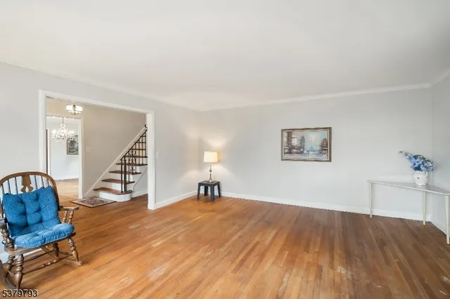 a view of a livingroom with wooden floor and a staircase