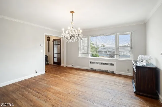 a view of a room with window wooden floor and chandelier