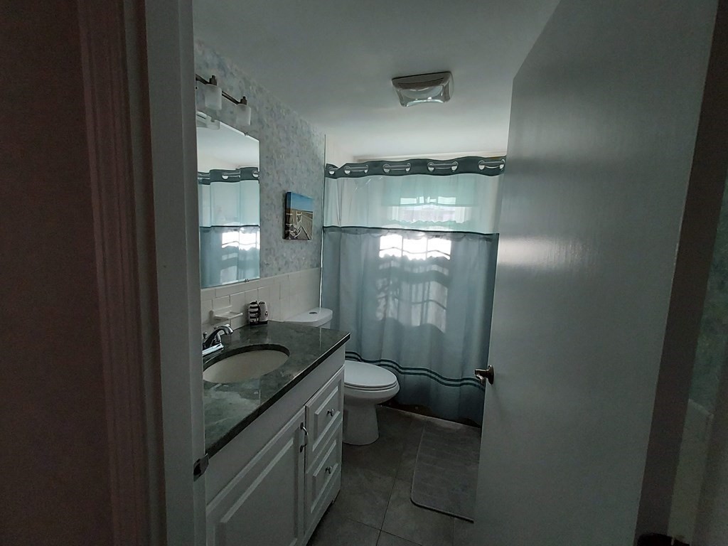 41 Dunstable Cross Road South Dennis, MA 02660 - Photo 27 of 38 a bathroom with a granite countertop sink a toilet and shower