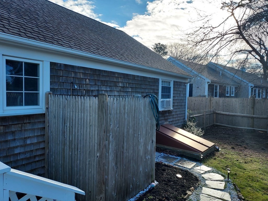 41 Dunstable Cross Road South Dennis, MA 02660 - Photo 33 of 38 a backyard of a house with wooden fence and large trees