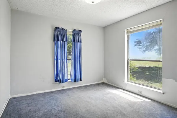 an empty room with windows and closet