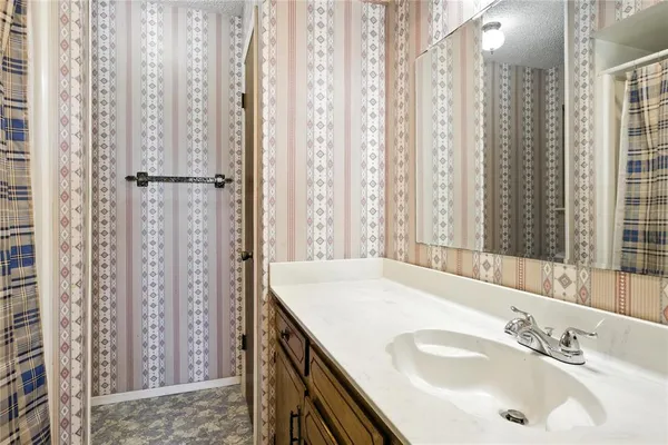 a bathroom with shower sink and a mirror
