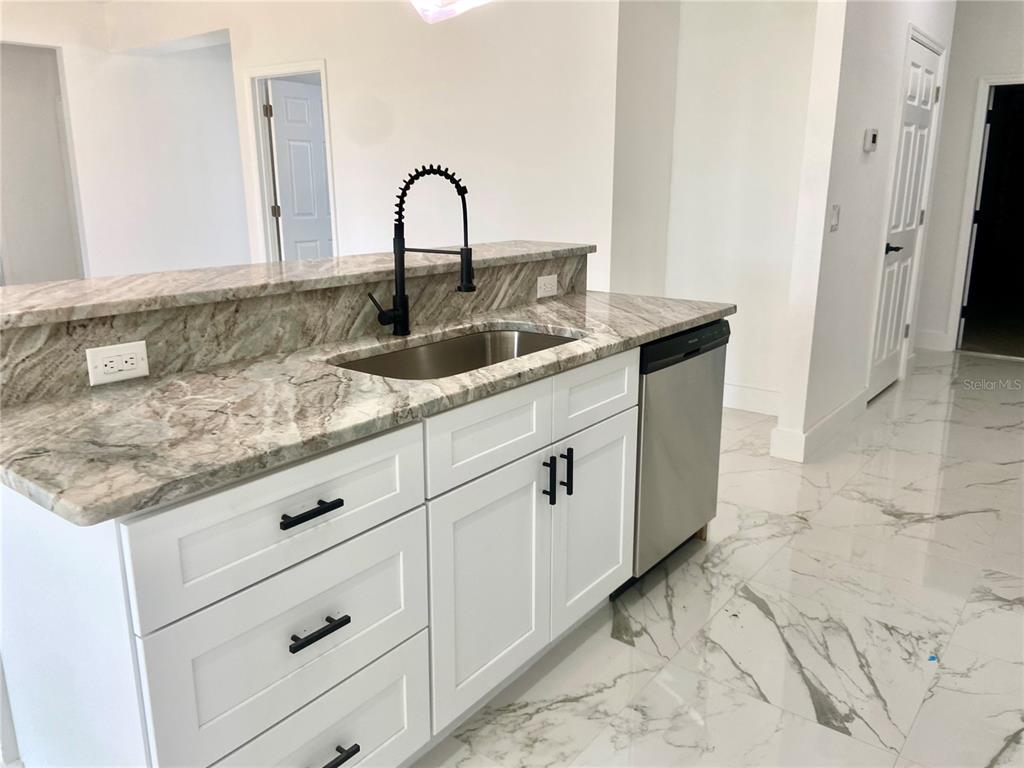 4501 Schumacher Road Sebring, FL 33872 - Photo 11 of 31 a kitchen with granite countertop white cabinets and sink