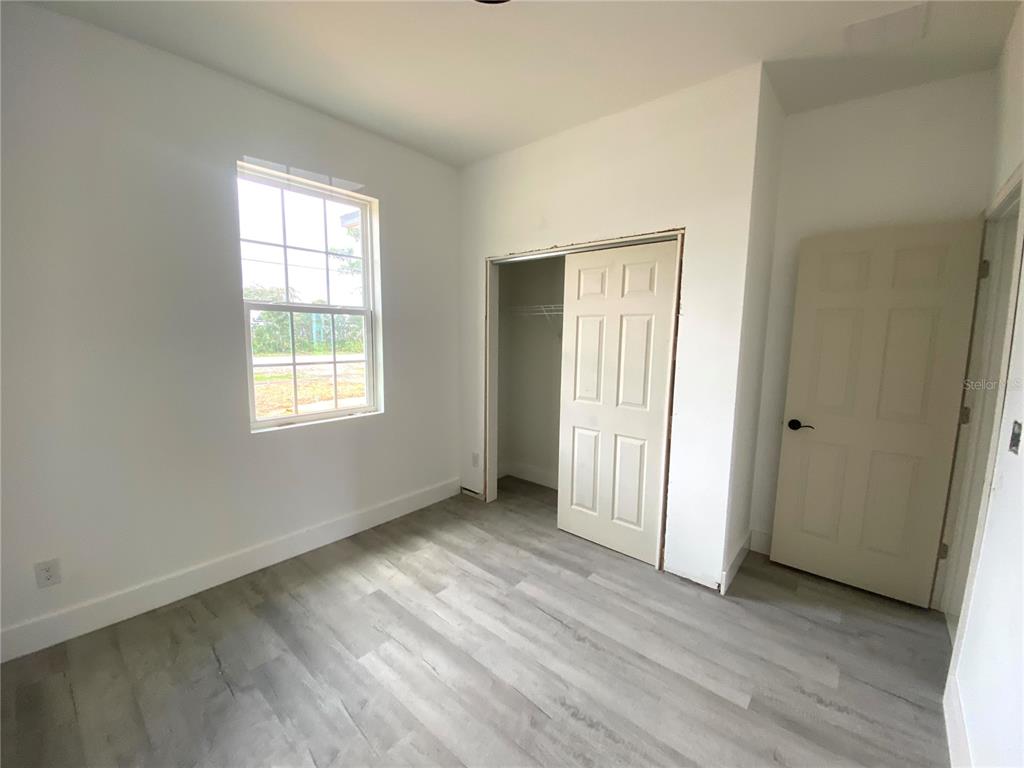 4501 Schumacher Road Sebring, FL 33872 - Photo 29 of 31 an empty room with wooden floor and windows