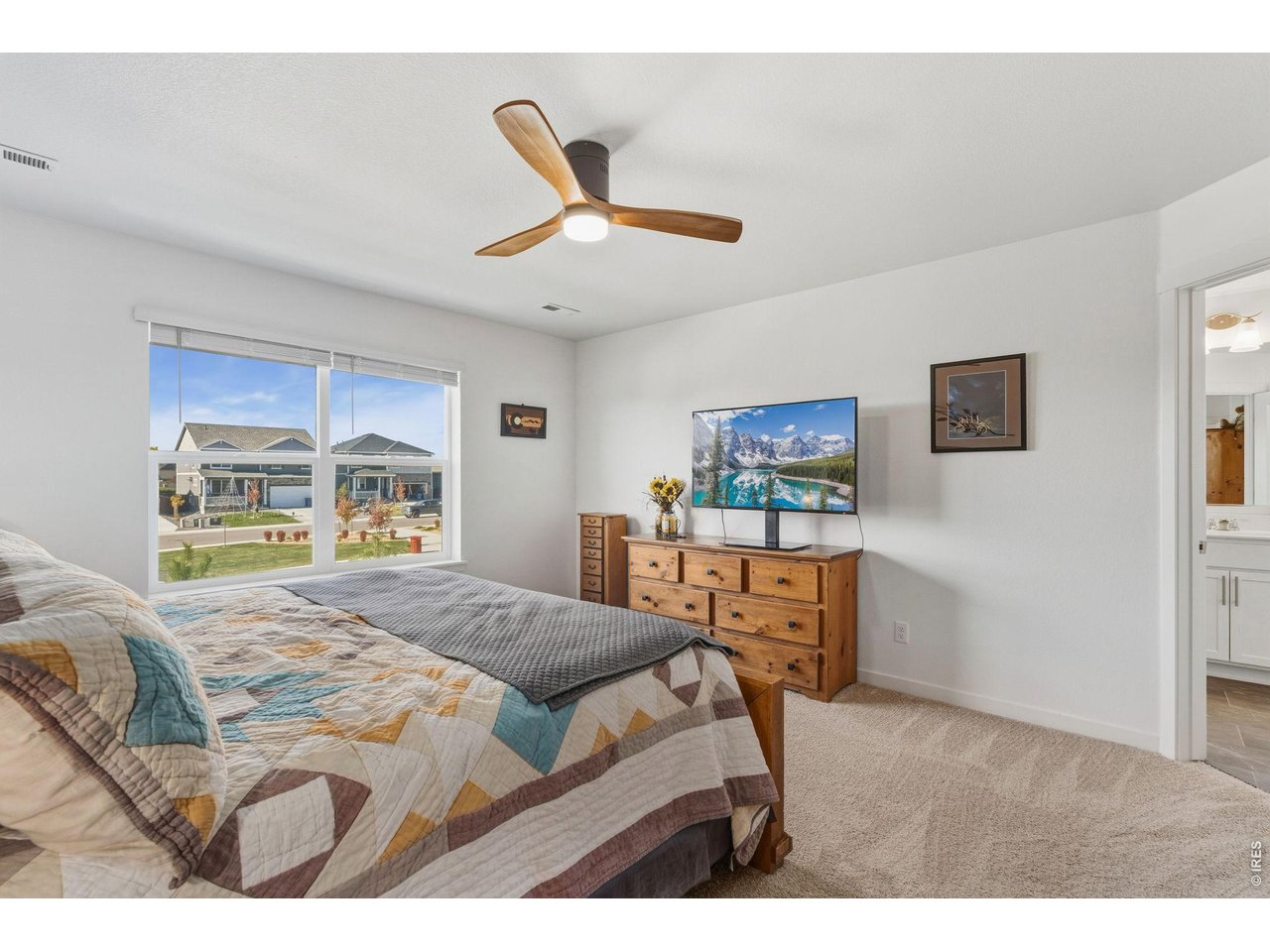 438 Bluebird Road Johnstown, CO 80534 - Photo 20 of 33 Generous primary suite with ceiling fan, the ensuite, and multiple windows overlooking open space and mountain views.