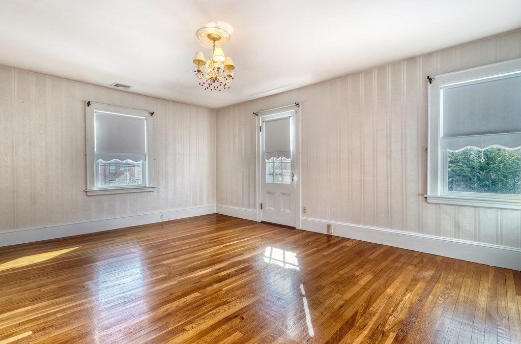 257 Lawrence Road Medford, MA 02155 - Photo 14 of 29 a view of an empty room with wooden floor and a window