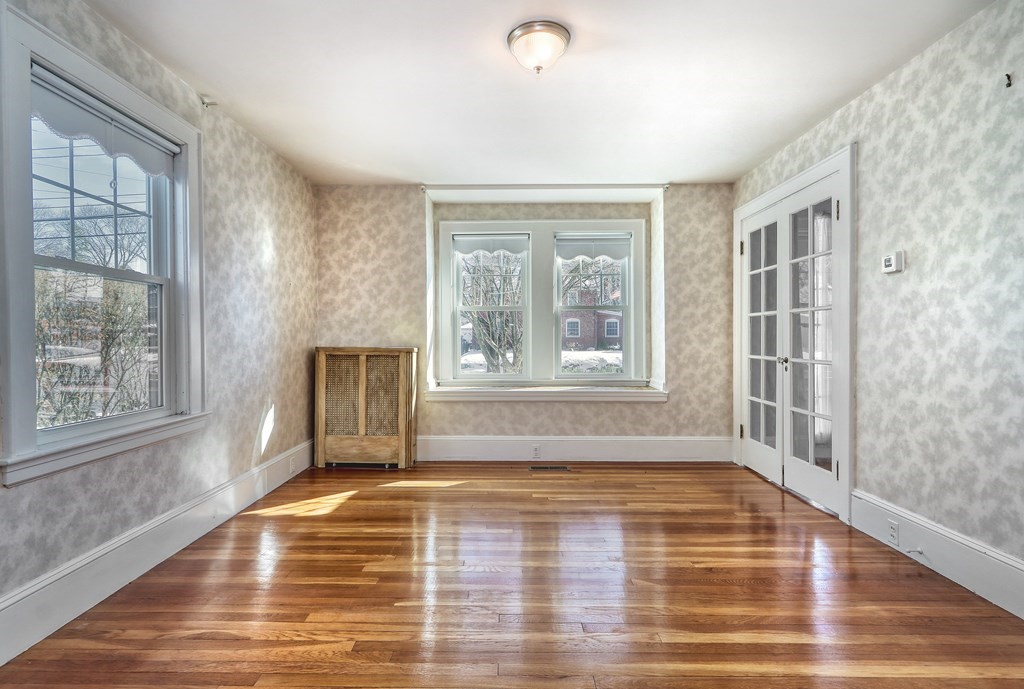 257 Lawrence Road Medford, MA 02155 - Photo 4 of 29 a view of an empty room with wooden floor and a window