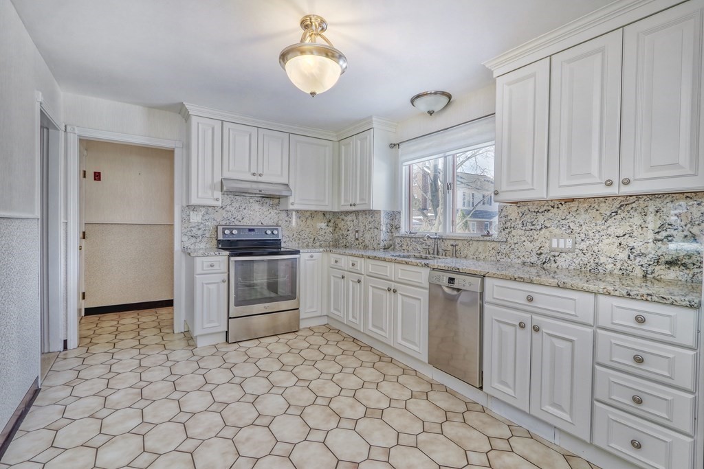 257 Lawrence Road Medford, MA 02155 - Photo 8 of 29 a kitchen with granite countertop a stove a sink and a refrigerator