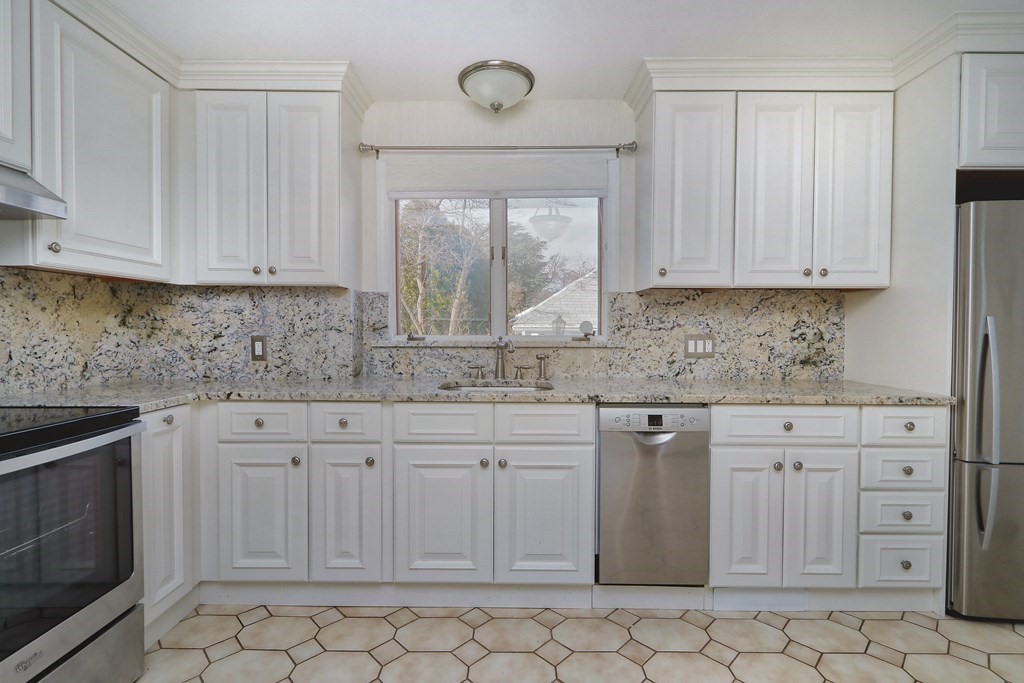 257 Lawrence Road Medford, MA 02155 - Photo 9 of 29 a kitchen with white cabinets granite counter tops and a window