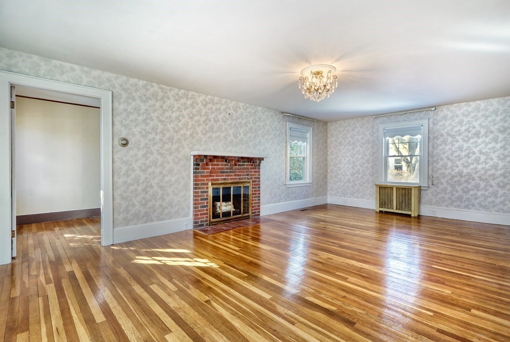257 Lawrence Road Medford, MA 02155 - Photo 10 of 29 an empty room with wooden floor fireplace and windows