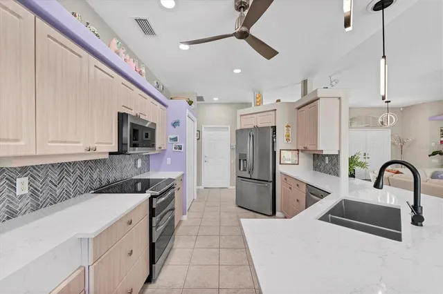 a kitchen with stainless steel appliances kitchen island granite countertop a sink a refrigerator and a stove
