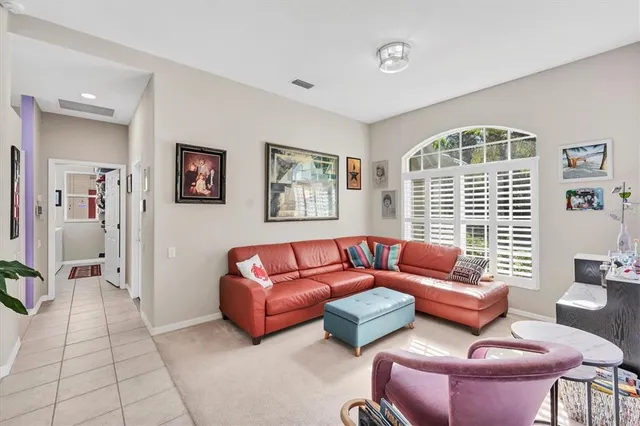 a living room with furniture a flat screen tv and a window