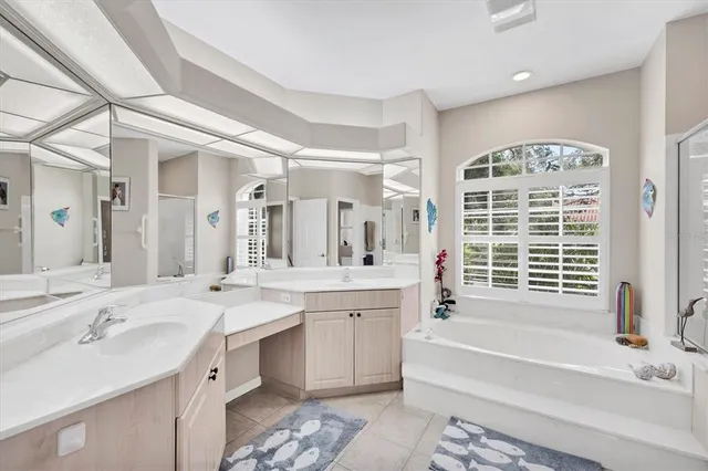 a spacious bathroom with a tub double sink and a large mirror