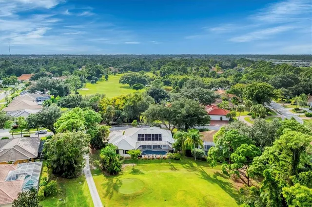 an aerial view of residential houses with outdoor space and trees