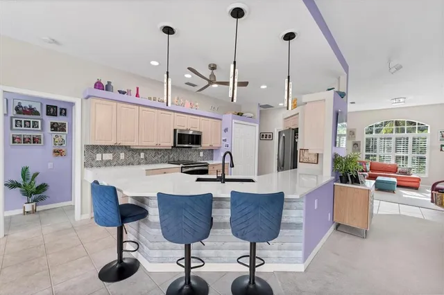 a kitchen with stainless steel appliances kitchen island granite countertop a table and chairs in it