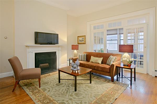 315 Beacon Street, Unit 5 Boston, MA 02116 - Photo 2 of 10 a living room with furniture a flat screen tv and a fireplace