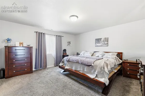 a spacious bedroom with a bed and a dresser