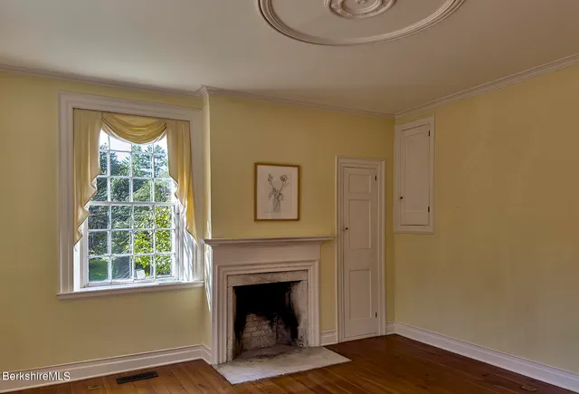 a view of a hallway with wooden floor and closet