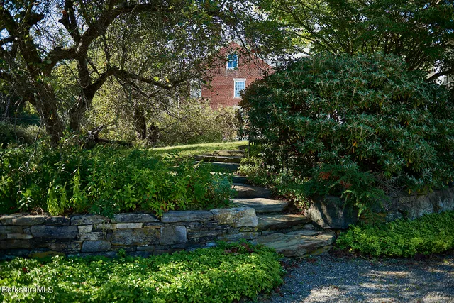 a backyard of a house with lots of green space and a fountain