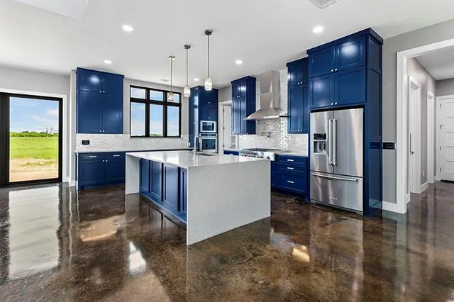 a large kitchen with stainless steel appliances kitchen island granite countertop a stove and a cabinets